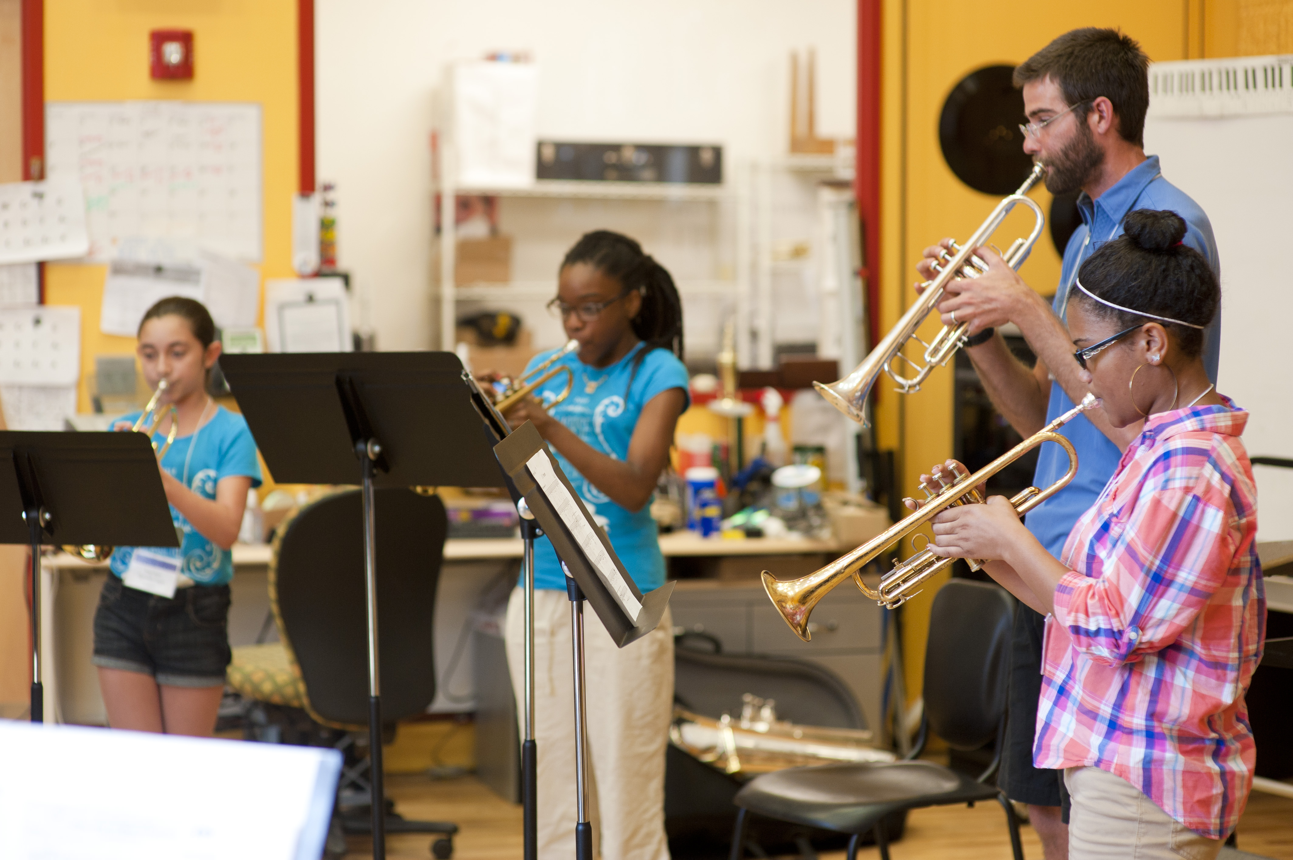 Teaching Artist playing trumpet with NHPS students