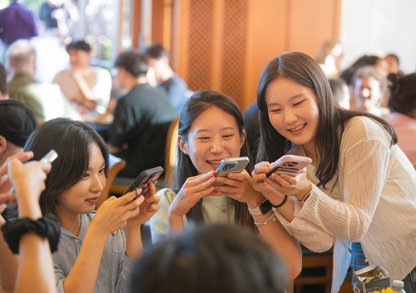 Three students looking at phones