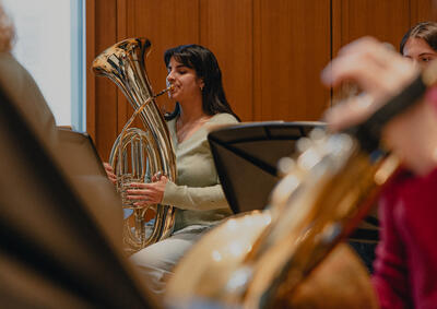 young woman with brown hair playing a tuba